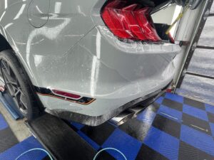 The rear bumper of a mustang getting paint protection film settling