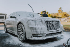 White Chrysler with PPF being hand washed for maintenance