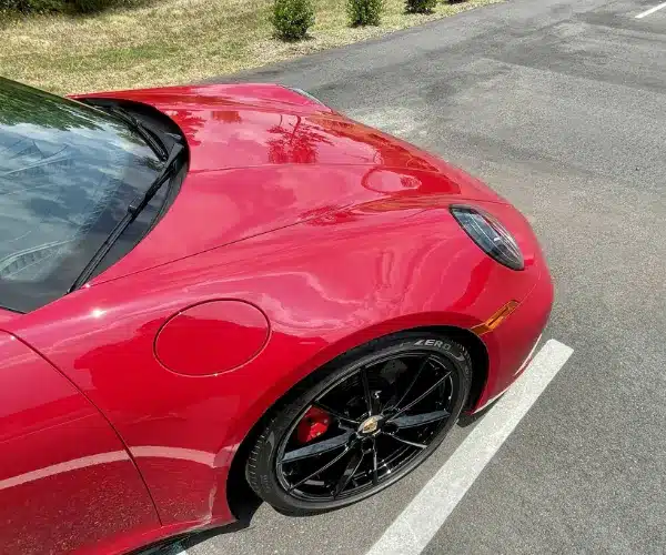 A close-up view of the hood and front fender of a red high-performance car,