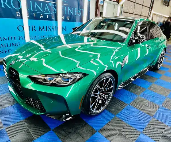 view of a luxury vehicle's hood showing a deep mirror reflection after a professional ceramic coating application
