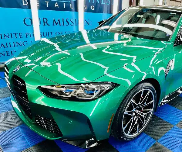 view of a luxury vehicle's hood showing a deep mirror reflection after a professional ceramic coating application